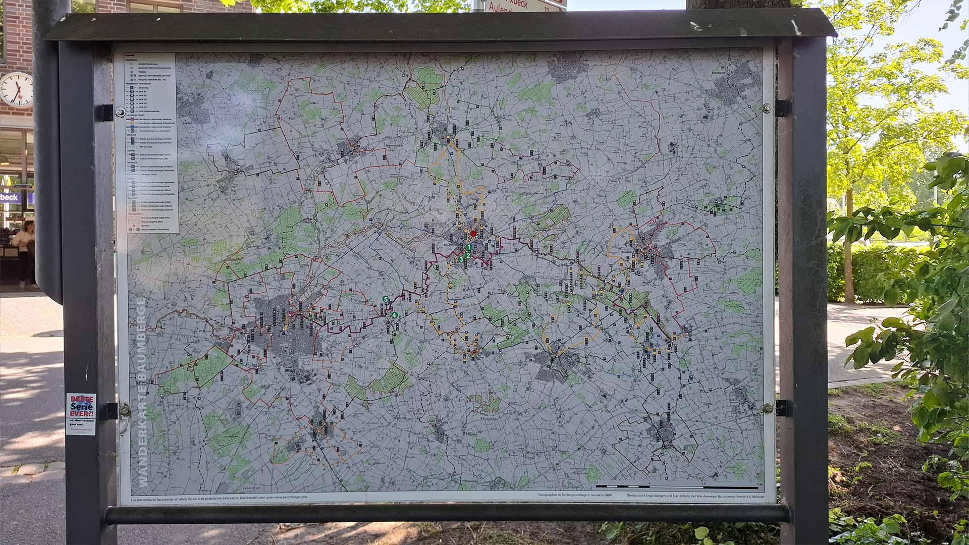 Detaillierte Wander‑ und Radkarte am Bahnhof Billerbeck, Routenübersicht in Infotafel, schattiger Platz unter Bäumen