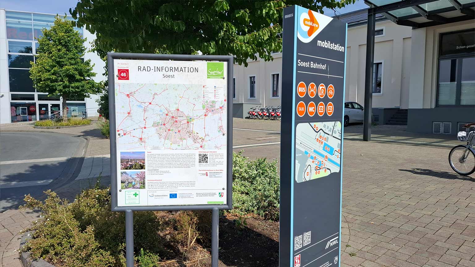 Rad-Informationskarte und Mobilstations-Stehle am Bahnhof Soest, Hinweise zu Radrouten und Angeboten wie Bus, Taxi und Carsharing