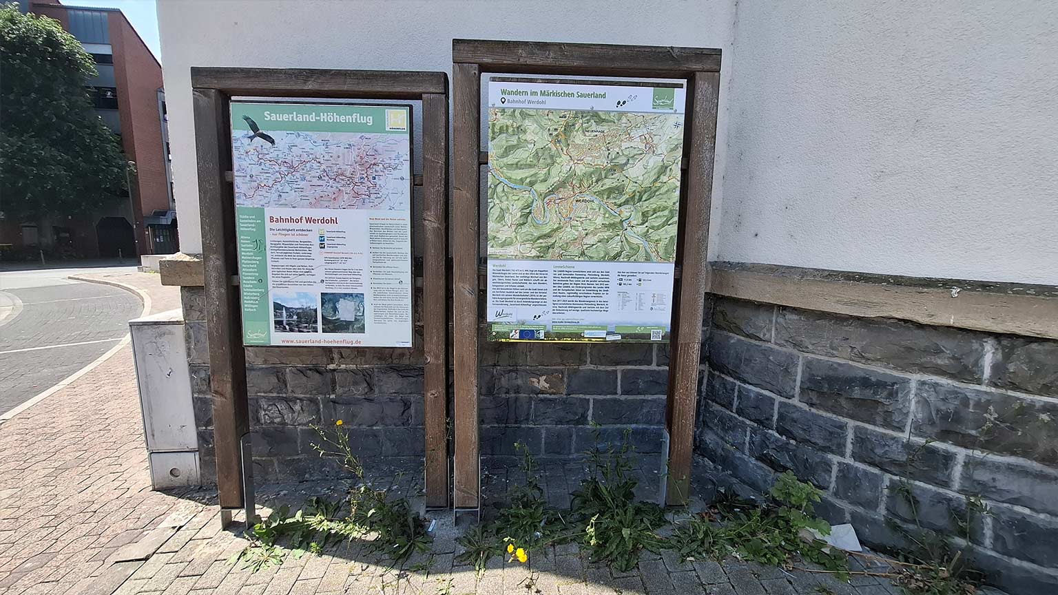 Infotafeln am Bahnhof Werdohl zu Sauerland‑Höhenflug und Wandern im Märkischen Sauerland, Holzrahmen an der Außenmauer