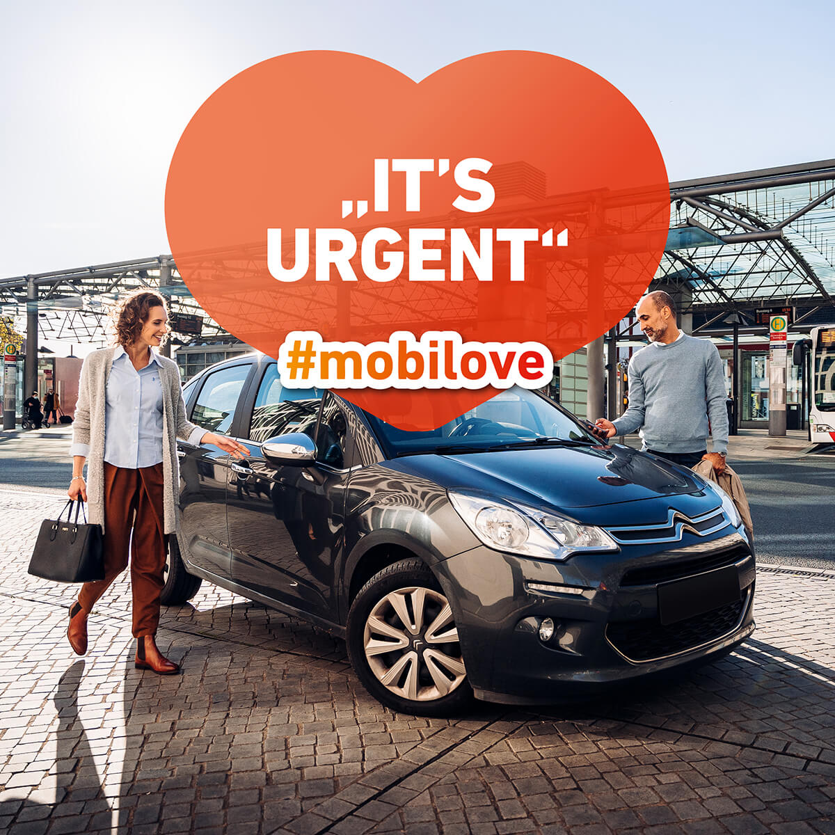 Mobilove-Visual: Mann und Frau steigen aus einem schwarzen Auto aus. In der Herzchen-Kommentarblase steht "It's urgent"