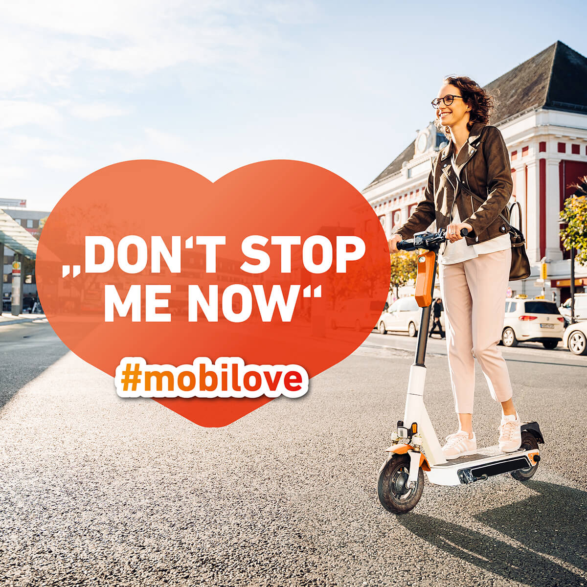 Mobilove-Visual: Junge Frau fährt auf einem Escooter, die Herzchenblase im Bild: "Don't stop me now"