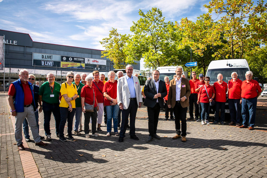 Rolf Peuster, Geschäftsführer Pro Bürgerbus NRW e.V., Oliver Krischer, Minister für Umwelt, Naturschutz und Verkehr des Landes Nordrhein-Westfalen, und Franz Heckens, Vorsitzender Pro Bürgerbus NRW e.V., gemeinsam mit Bürgerbusfahrer*innen aus NRW.