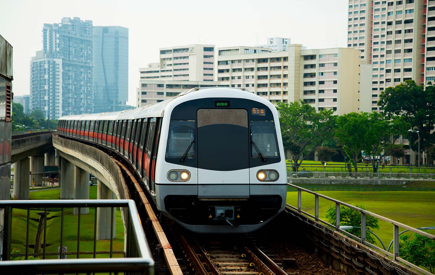 Ein Mass Rapid Transit fährt in Singapur über eine Schienenbrücke.