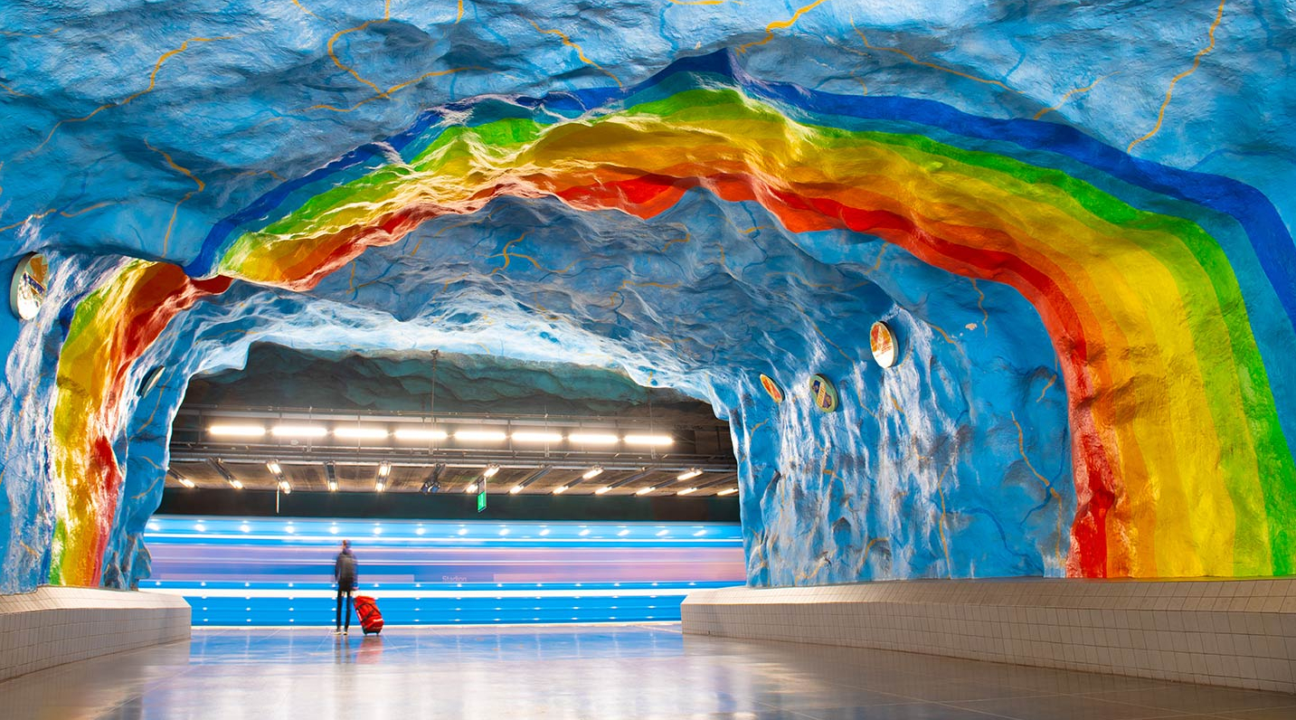 Eine U-Bahn-Station in Stockholm, deren Wände und Decke wie ein Regenbogen angemalt sind.