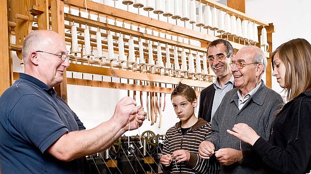 Ansicht einer Gruppe Museumsbesucher, die eine Führung zur Funktion der Spinnmaschine im LVR Industriemuseum Ratingen bekommen. LVR-Industriemuseum, Ratingen