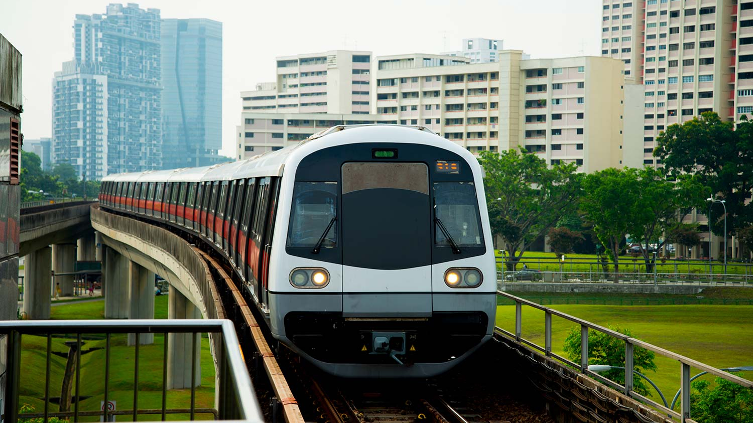 Ein Mass Rapid Transit fährt in Singapur über eine Schienenbrücke.