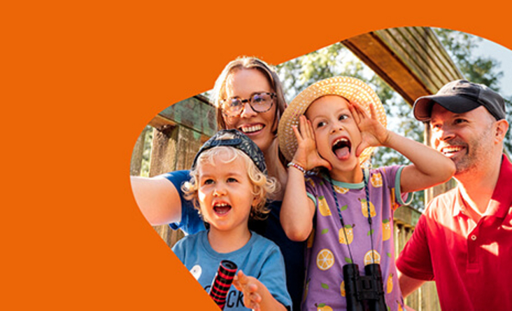 Zu sehen ist eine vierköpfige Familie, welche auf einer Brücke ein Selbsportrait zusammen mit dem Handy macht. 