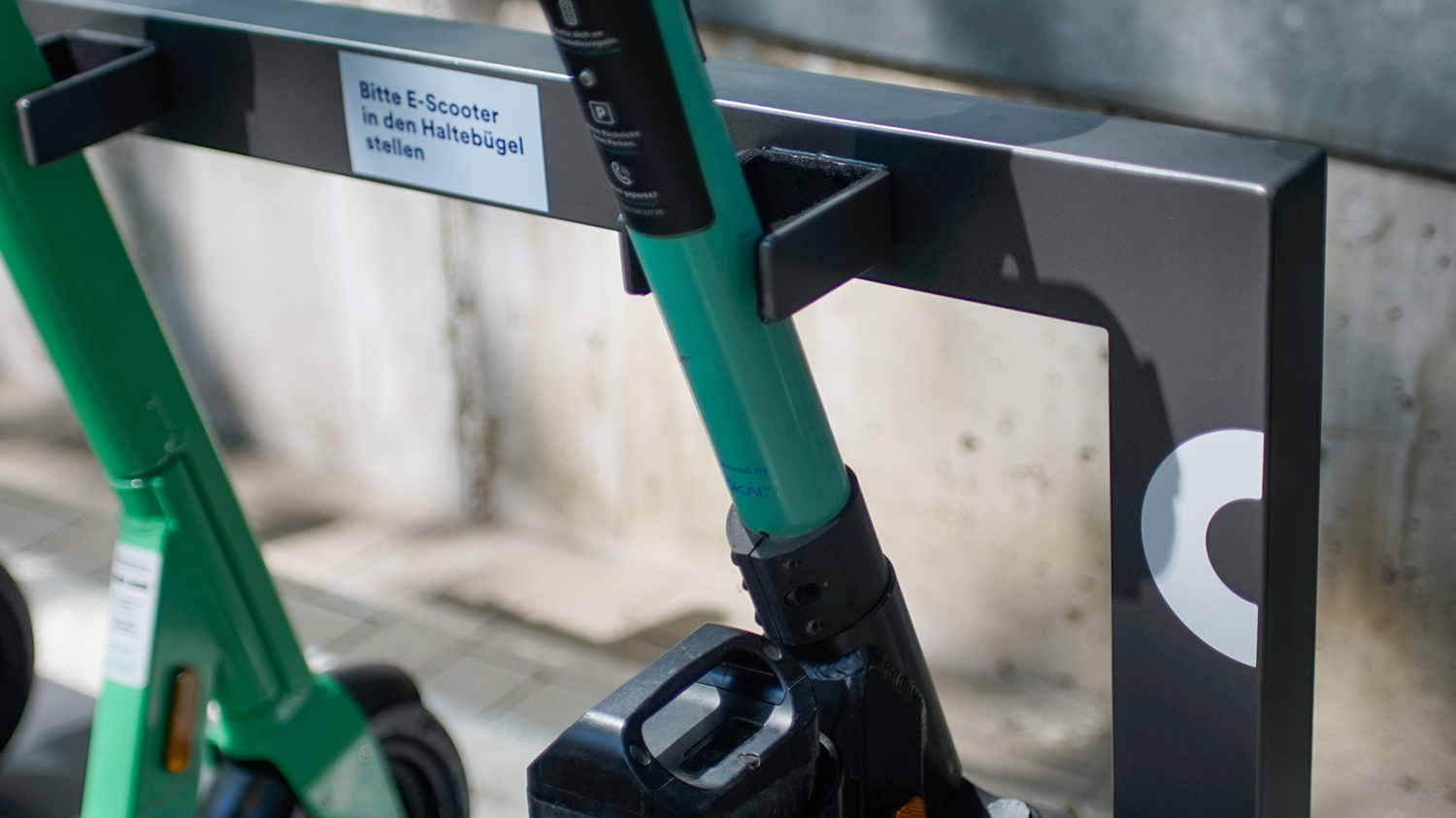 Nahaufnahme von E-Scootern, die an einer Mobilstation in der Ladestation stehen.