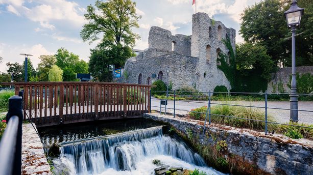 Ansicht von Bad Lippspringe mit der Lippequelle und der Burg im Hintergrund. Bad Lippspringe