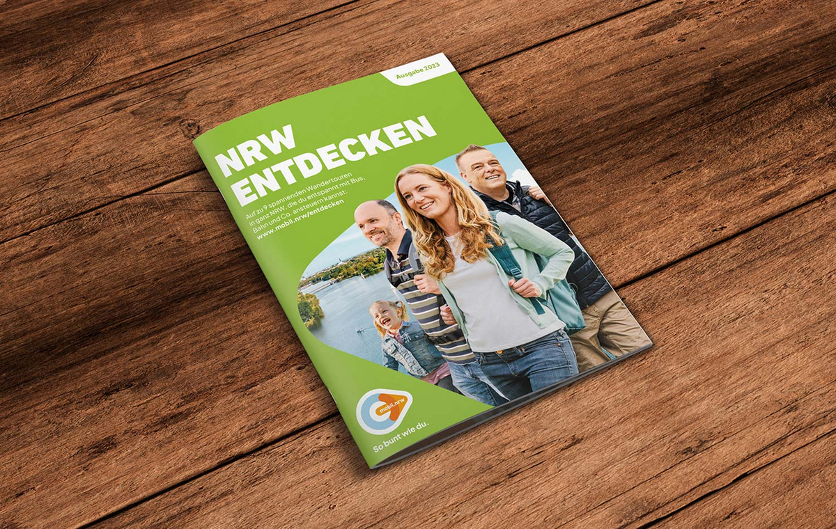 Der Wanderfolder 2023 liegt auf einem Holzhintergrund