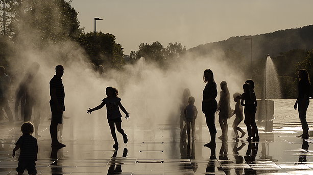 Kinder beim Spielen auf der Wasserfläche, die mit Wasserfontänen und Nebeldüsen ausgestattet ist. Sauerlandpark, Hemer