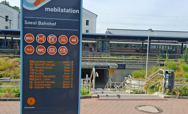Mobilstation Soest am Bahnhof mit digitaler Abfahrtsanzeige für Bus und Bahn, Zugang zur Unterführung und Bahnsteige im Hintergrund