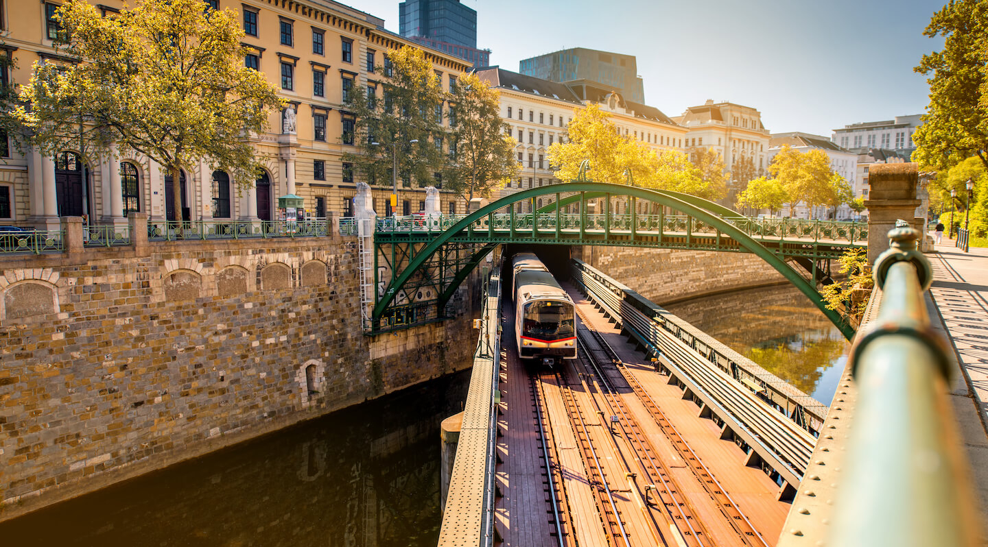 U-Bahn fährt über eine Brücke über einen Wasserkanal in Wien.