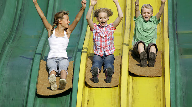 Kinder beim Das Rutschen auf der Teppichrutsche im Bubenheimer Spieleland Nörvenich ist ein reines Vergnügen. Bubenheimer Spieleland, Nörvenich