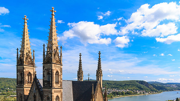 Ansicht der Appolinaris-Kirche Remagen bei wolkenlosen Himmel. Die Kirche wurde direkt am Rheinufer erbaut, so dass man den anliegenden Rhein und sein Ufer sieht. Apollinariskirche, Remagen