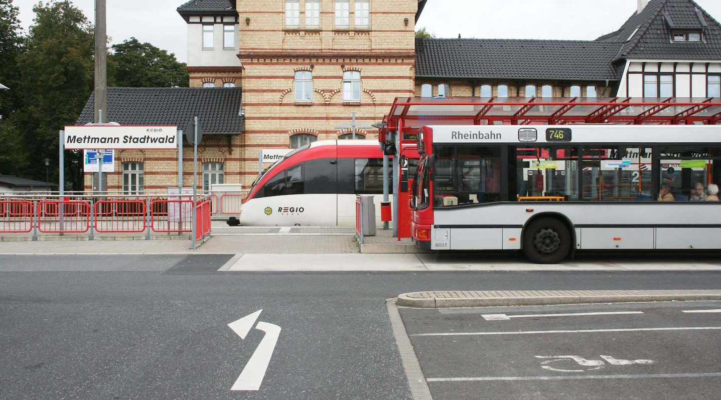 Blick auf den Bahnhof Mettmann Stadtwald mit der S28 und einer Buslinie