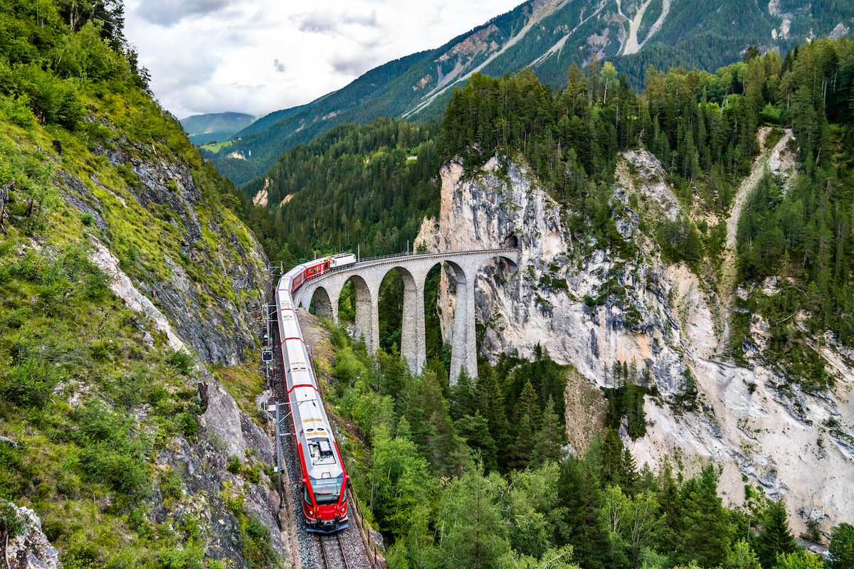 Eine rote Bahn, welche durch die Berge fährt.