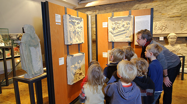 Ansicht einer Gruppe Kinder mit ihrem Lehrer beim Betrachten von Exponaten im Baumberger Sandstein-Museum Havixbeck. Baumberger Sandstein-Museum, Havixbeck
