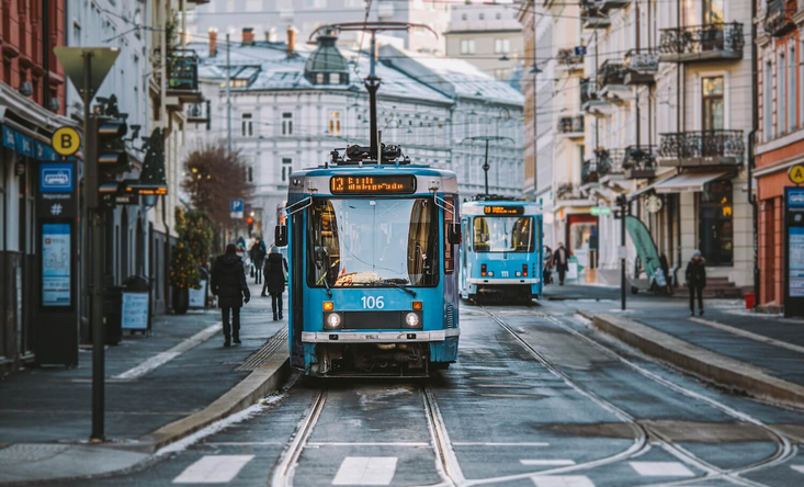 Eine blaue Straßenbahn fährt durch die Straßen in Oslo.