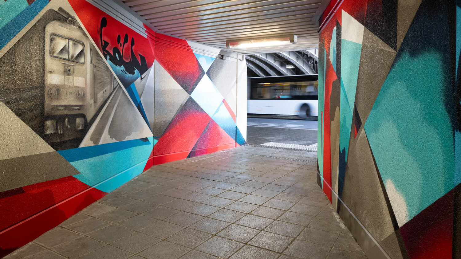 Die Unterführung am Bahnhof Köln Nippes, die durch moderne Streetart verziert ist.